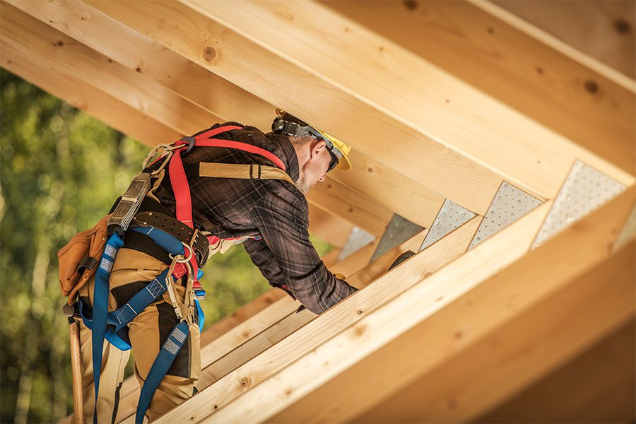 Specialized Business Insurance - Portrait of a Contractor Working on Framing a New Roof for a Home Construction Project